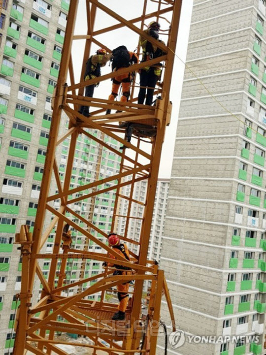 119 구조대원들이 지난 10일 경기 의정부 민락2택지개발지구 건설공사 현장에서 타워크레인이 넘어지면서 추락하다 크레인 중간에 걸린 근로자를 구조하고 있다.<LH 제공>